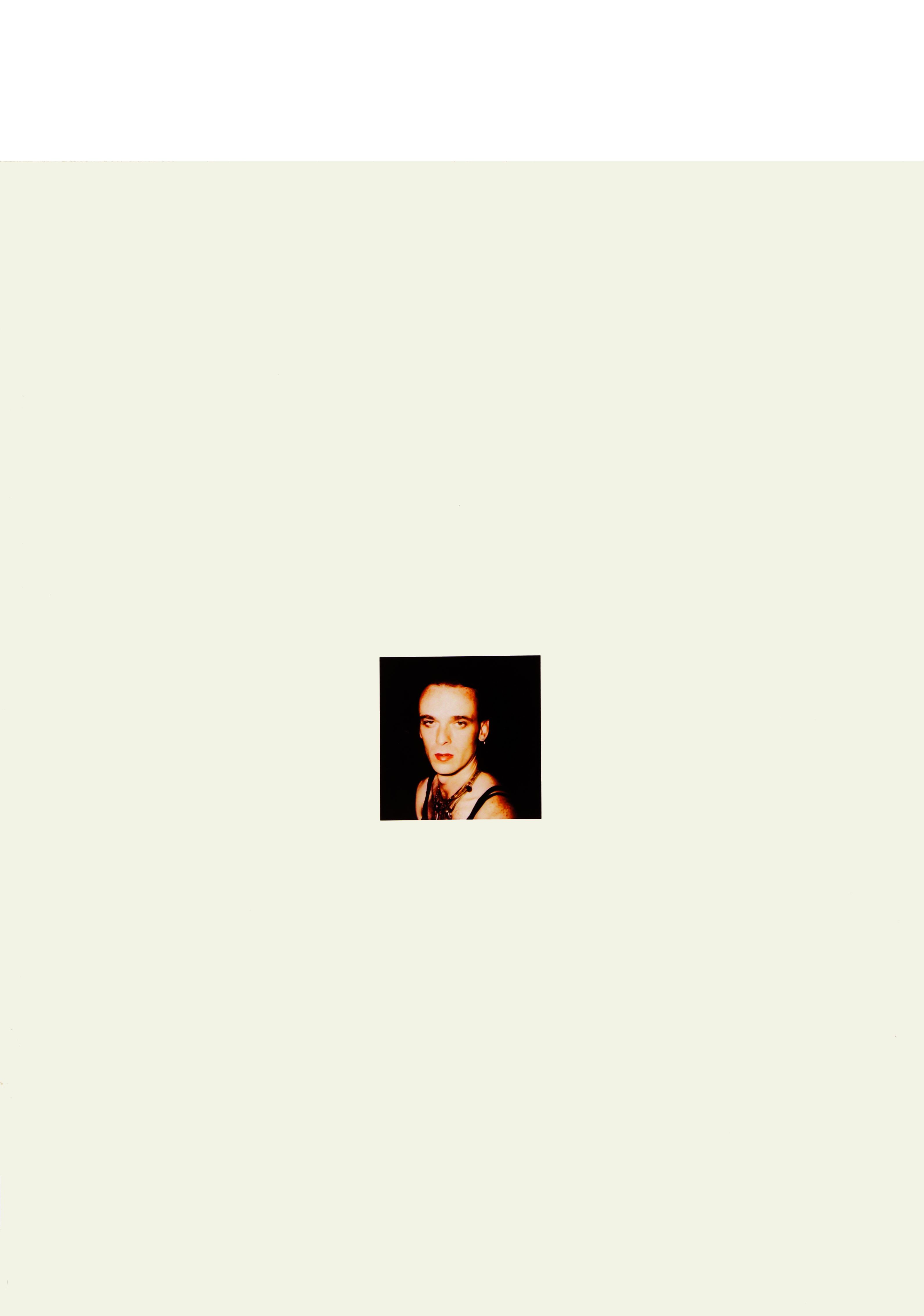A picture with a beige background. There is a photo in the centre. The photo shows a man looking into the camera.