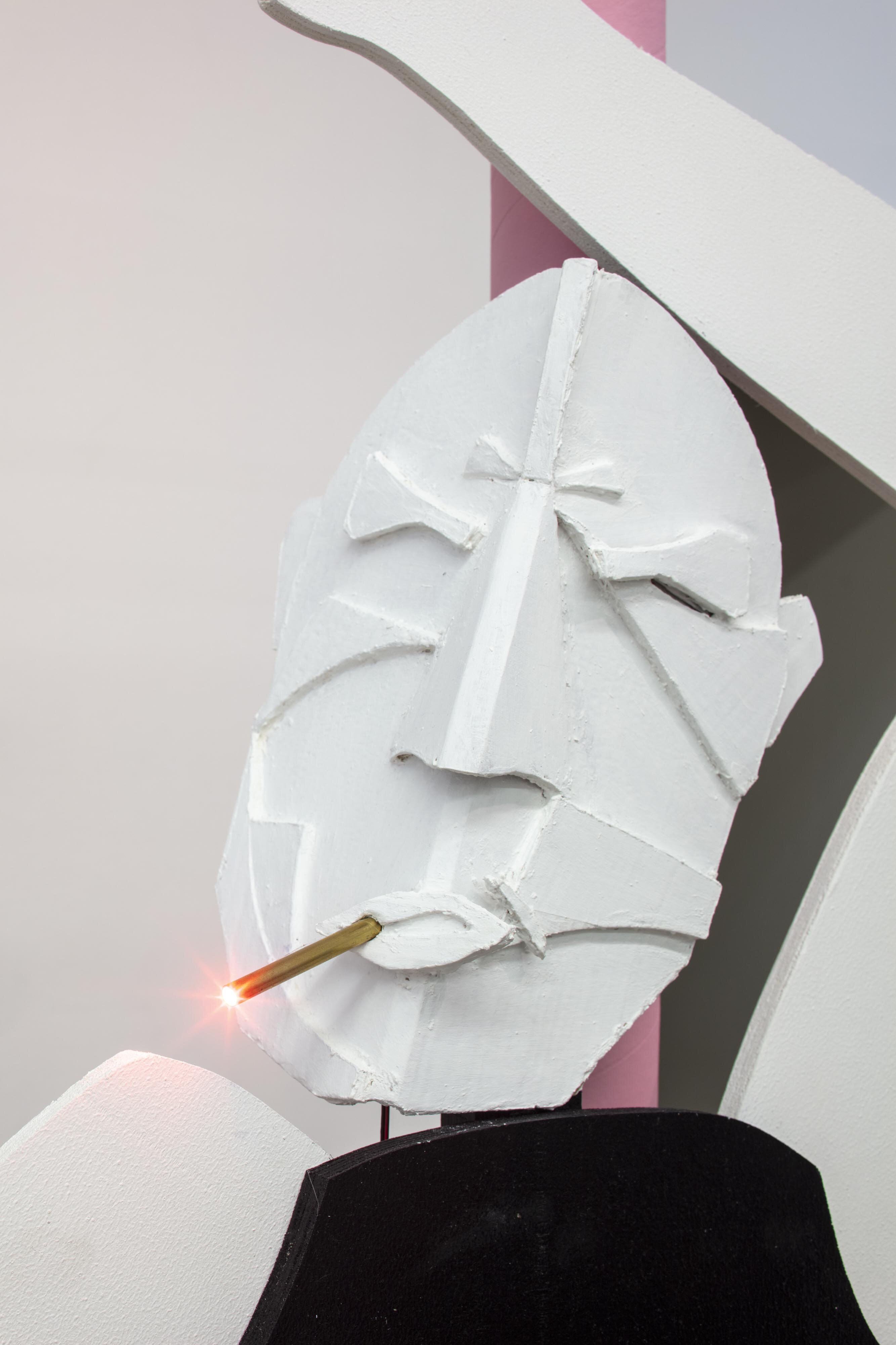 Sculpture of a man made of cardboard leaning against a lantern with a lit cigarette in his mouth