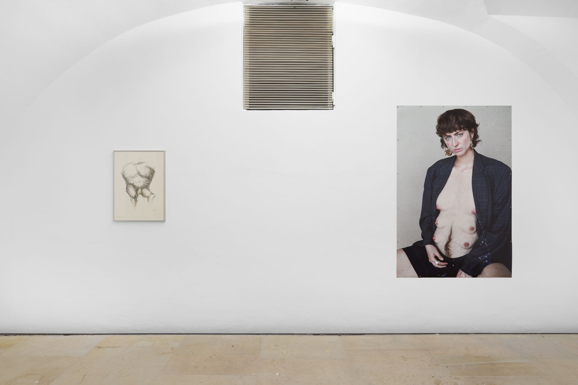 Milena Wojhan's work Lupa in a vaulted cellar on a white wall, to the right of a black and white drawing