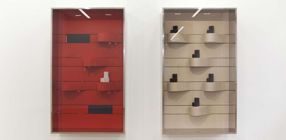 Picture from the exhibition with a red and a wooden showcase.