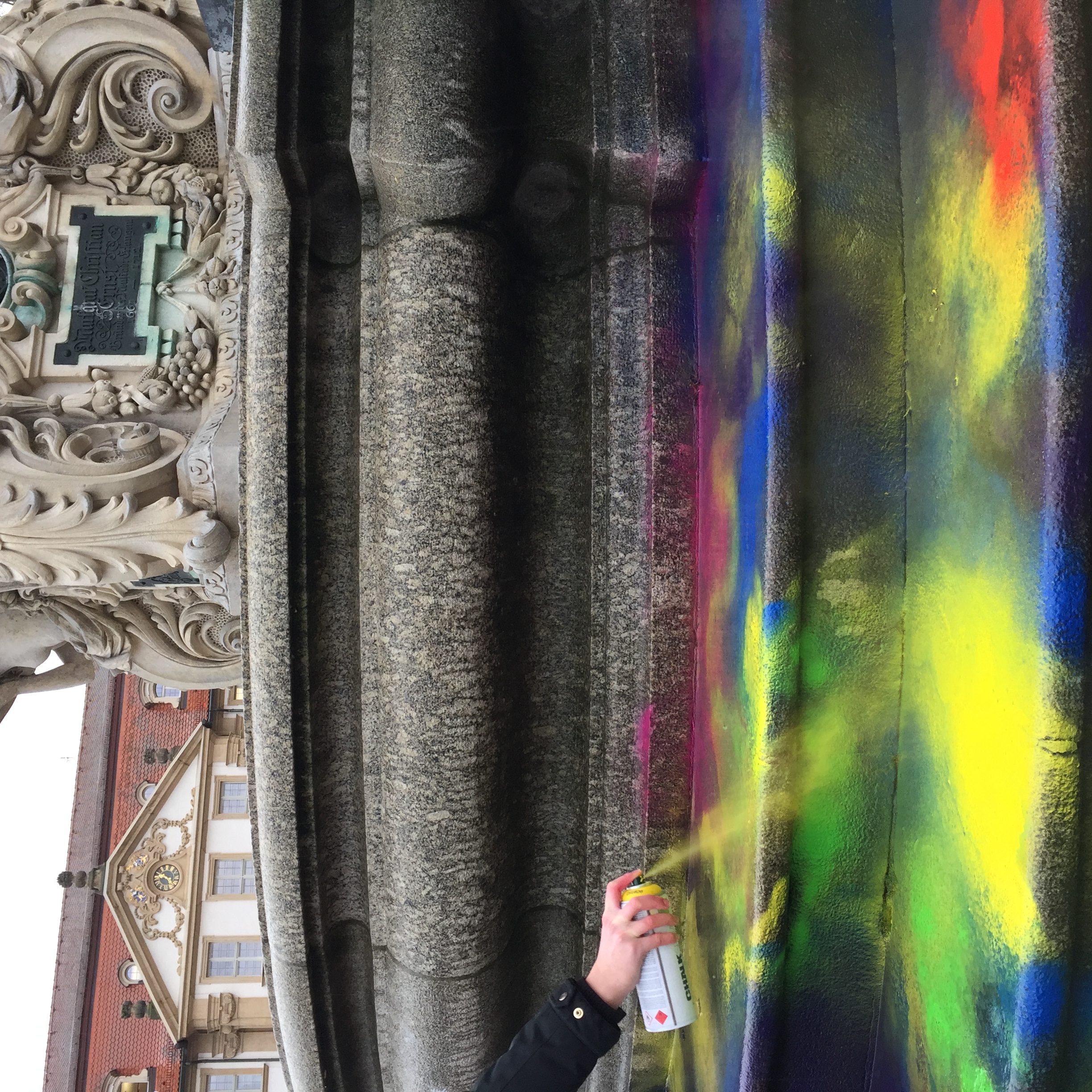 Während einer Kunstvermittlungsaktion wird der Pauli-Brunnen in Erlangen mit abwaschbaren Farben angesprüht.