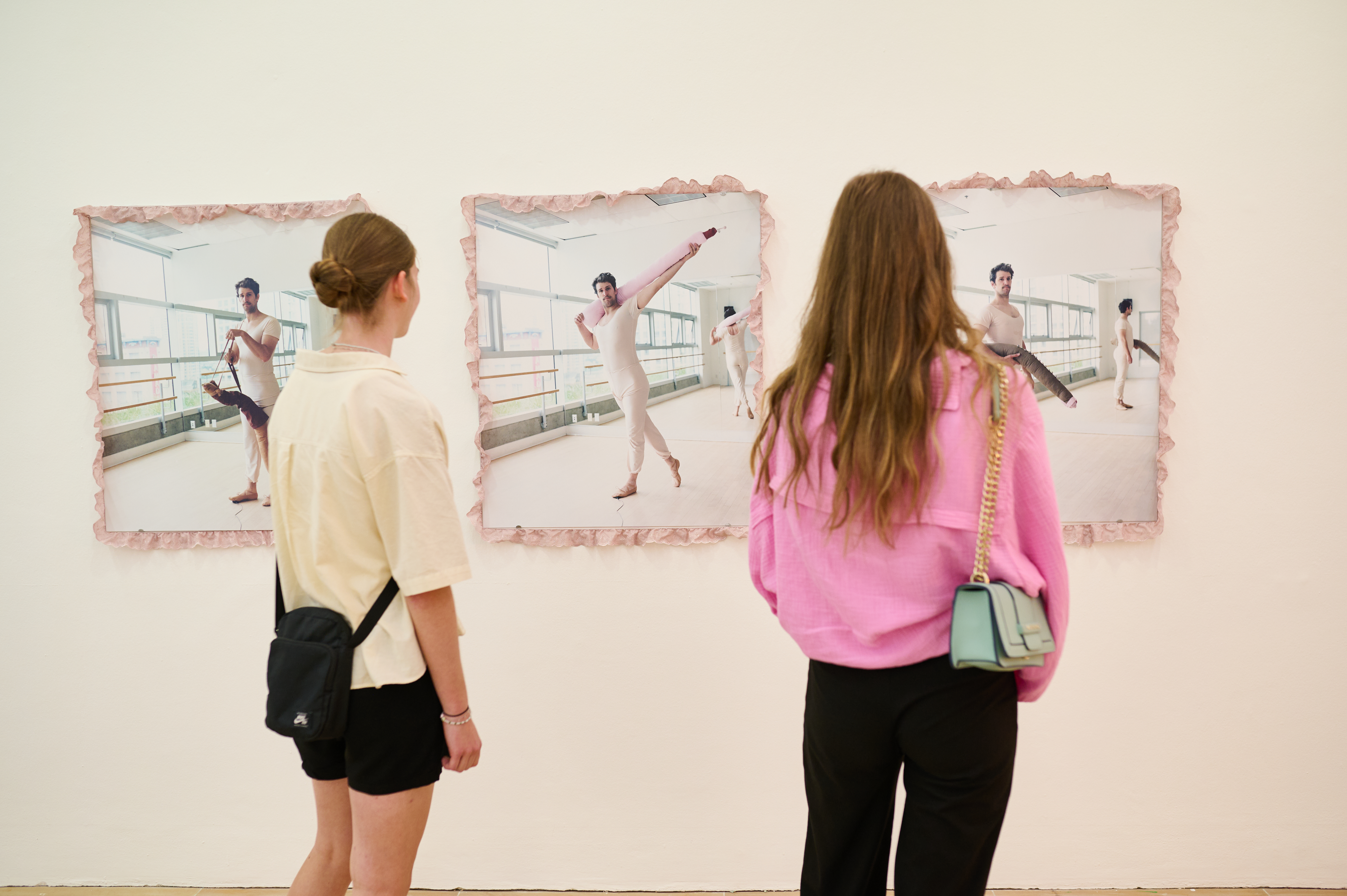 Two visitors look at works by Mike Bourscheid