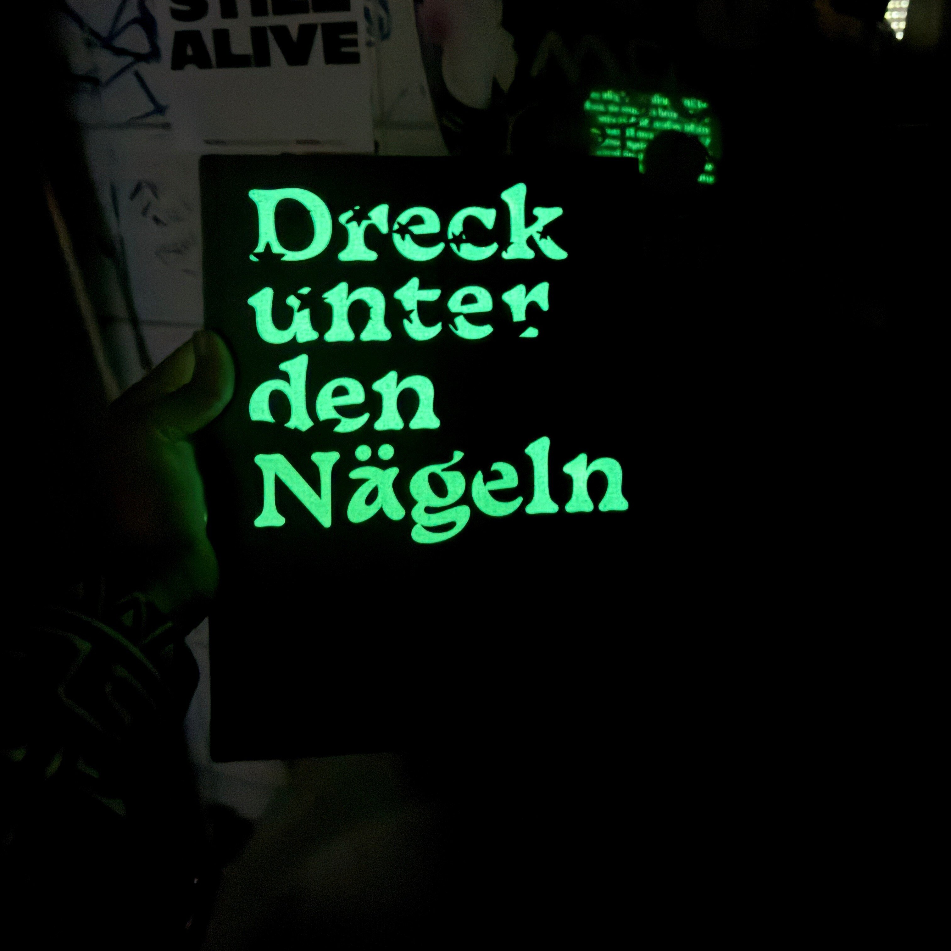 Image of Eva Nüßlein's catalog in the dark with glowing lettering